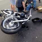 crashed motorcycle with an injured rider laying